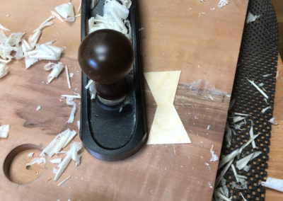 Das Butterfly Inlay auf der Unterseite des Couchtisches wird mit dem Hobel bearbeitet