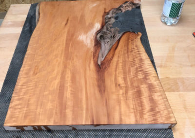 Die Tischplatte des Three-Wood-Tables wird gewässert. Zum ersten Mal wird die Schöne Maserung des Holzes sichtbar.