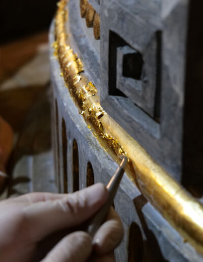 Polieren von angeschossenem Blattgold mit dem Achatstein während der Polimentvergoldung.