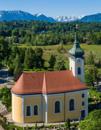 St. Michaelskirche in Seehausen am Staffelsee mit Blick auf den Kirchturm und die Voralpenlandschaft in Oberbayern.